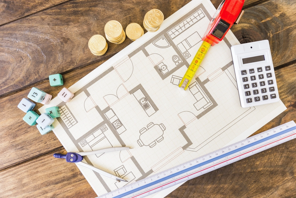 divider-ruler-math-blocks-calculator-stacked-coins-blueprint-wooden-desk